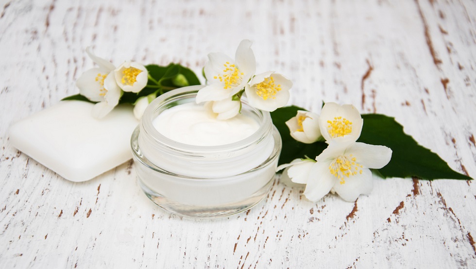 face and body cream moisturizers with jasmine flowers on white w